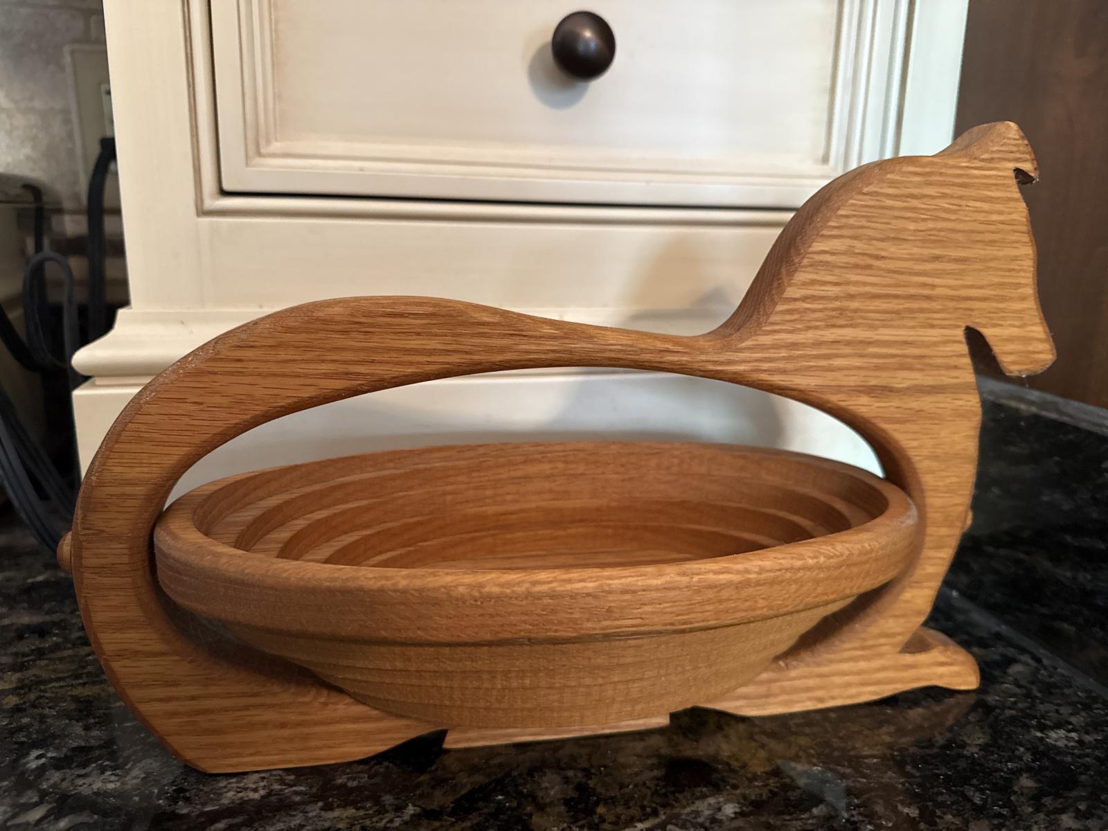 Wooden collie-shaped basket side view on a countertop.