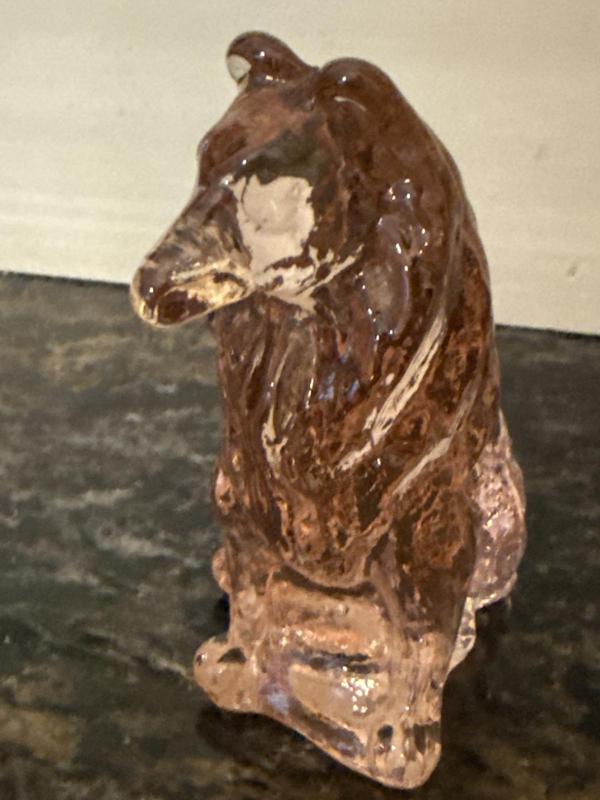 Front angle view of pink glass collie statue showing face details.