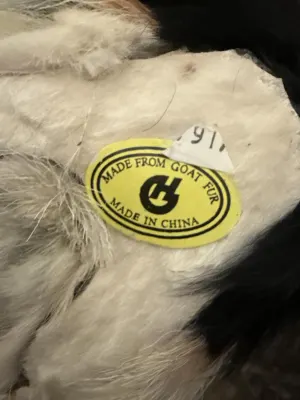 Label on collie figurine reading 'MADE FROM GOAT FUR, MADE IN CHINA'.