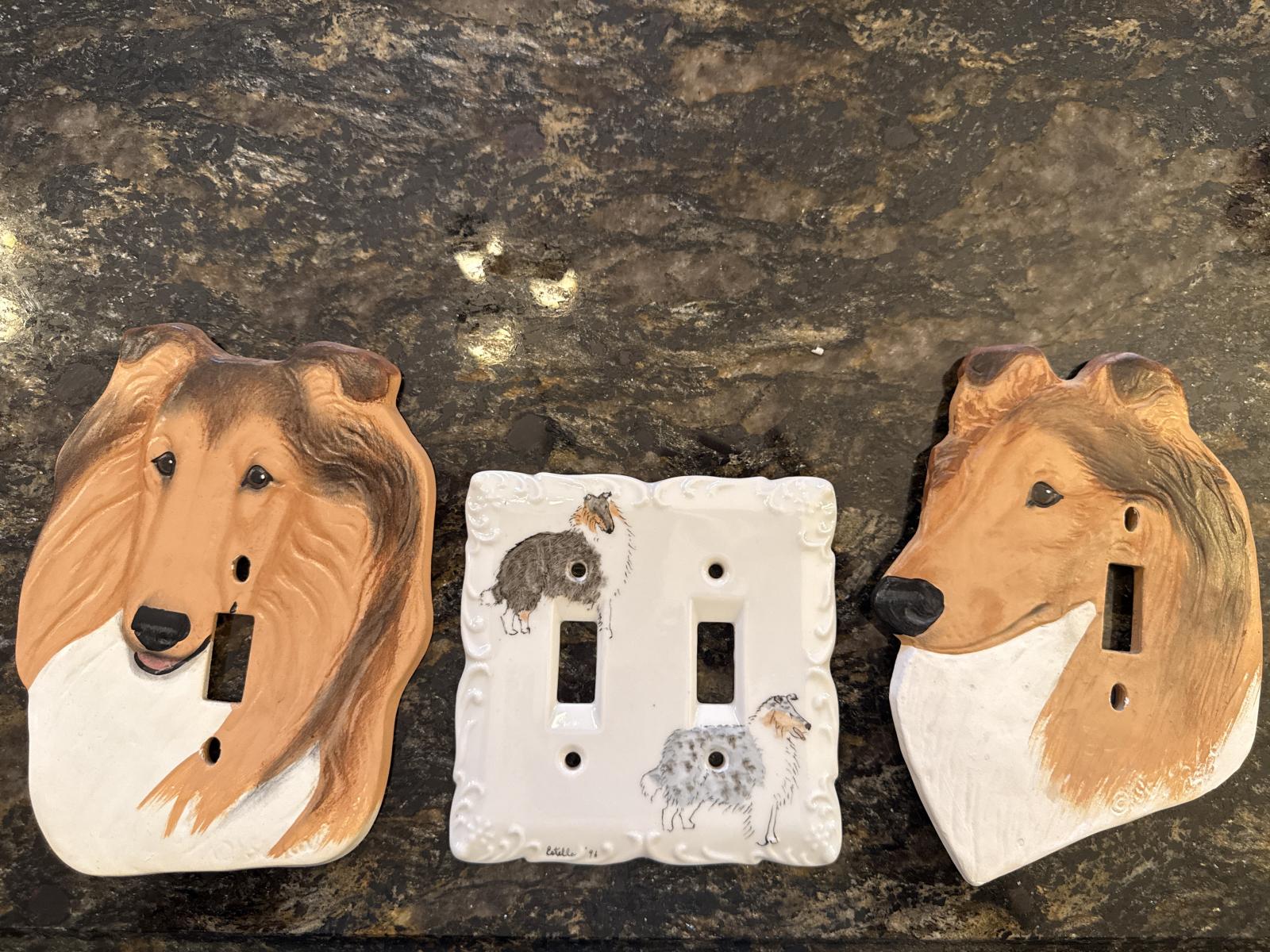 Three ceramic light switch covers with collie designs on a dark surface.