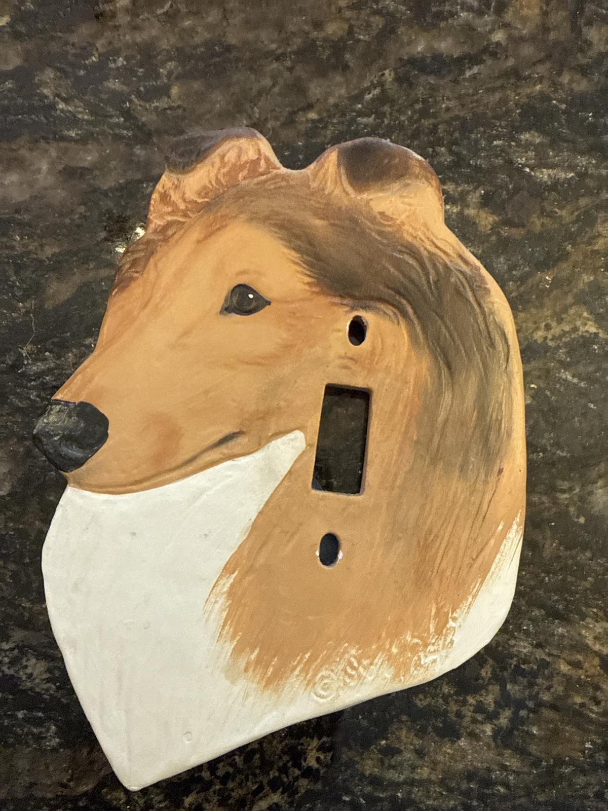 Collie head-shaped ceramic light switch cover, brown and white.