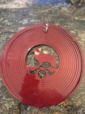 Red circular wind ornament with animal cutout and hanging hook.