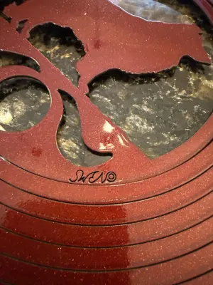 Close-up of red wind ornament with 'SWN' maker's mark.