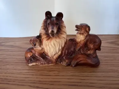 Ceramic collie family figurine with two puppies, brown and cream colors.